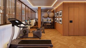 A modern gym with exercise equipment, wooden walls, and a herringbone floor pattern. - Palacio San Juan, A Royal Hideaway Hotel (Murcia)