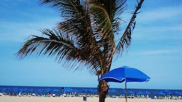 En la playa, camastros, sombrillas y toallas de playa 