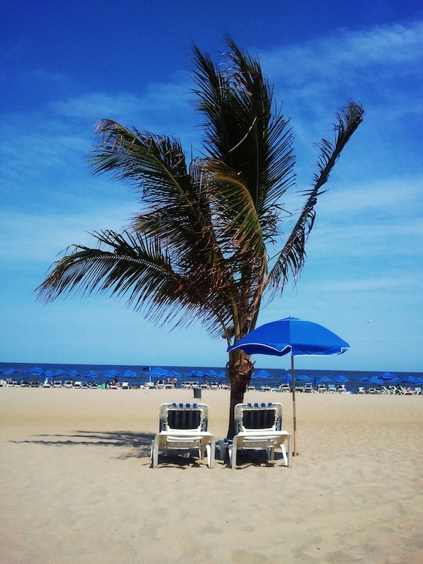 En la playa, camastros, sombrillas y toallas de playa 