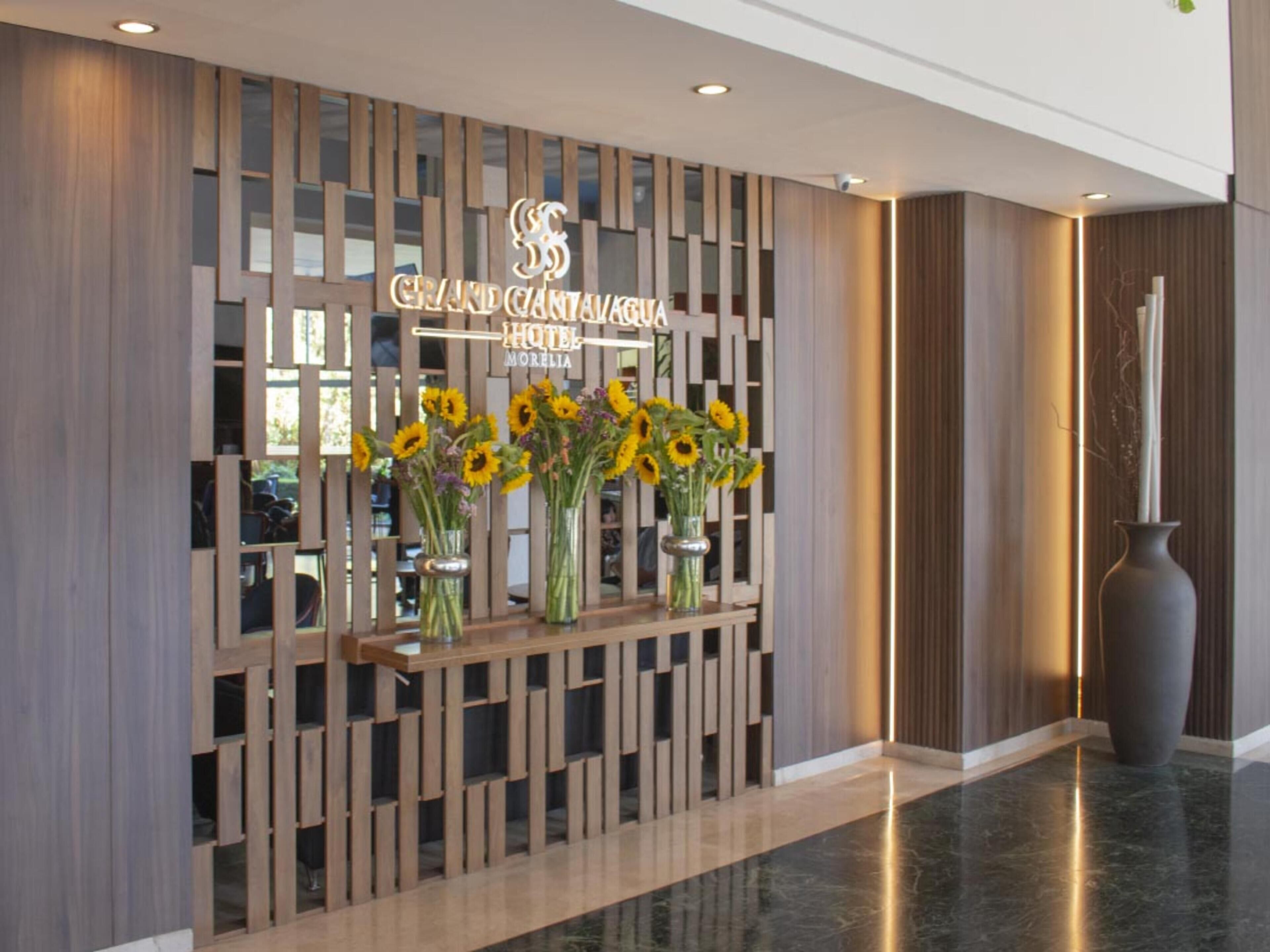 A reception desk with a modern design, featuring a wooden panel structure and a sign for the Grand Canyon Hotel.