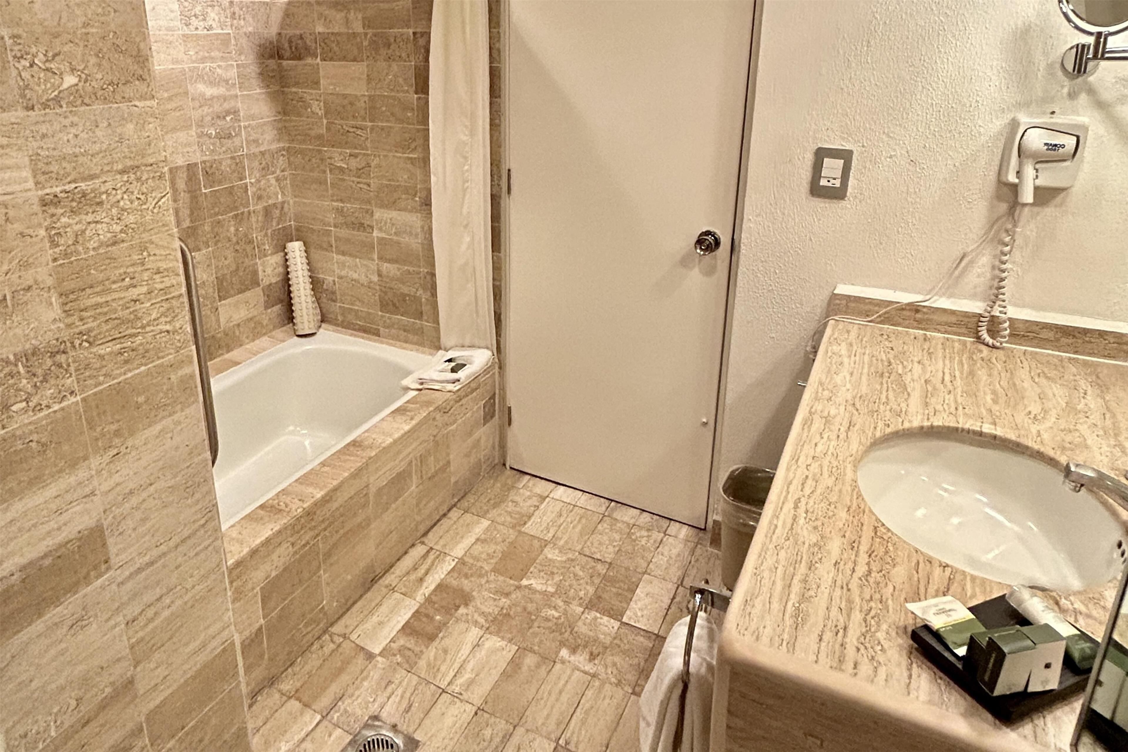 A bathroom with a bathtub, a sink, and a shower.