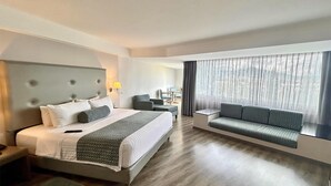 A modern hotel room with a large bed, a sofa, a desk, and a window with curtains. - Grand Cantalagua Hotel Morelia, BW Signature Collection (Morelia)
