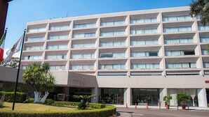 A multi-story hotel with a modern facade, large windows, and a well-maintained garden area. - Grand Cantalagua Hotel Morelia, BW Signature Collection (Morelia)