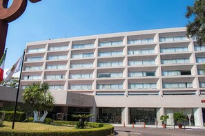 A multi-story hotel with a modern facade, large windows, and a well-maintained garden area. - Grand Cantalagua Hotel Morelia, BW Signature Collection (Morelia)