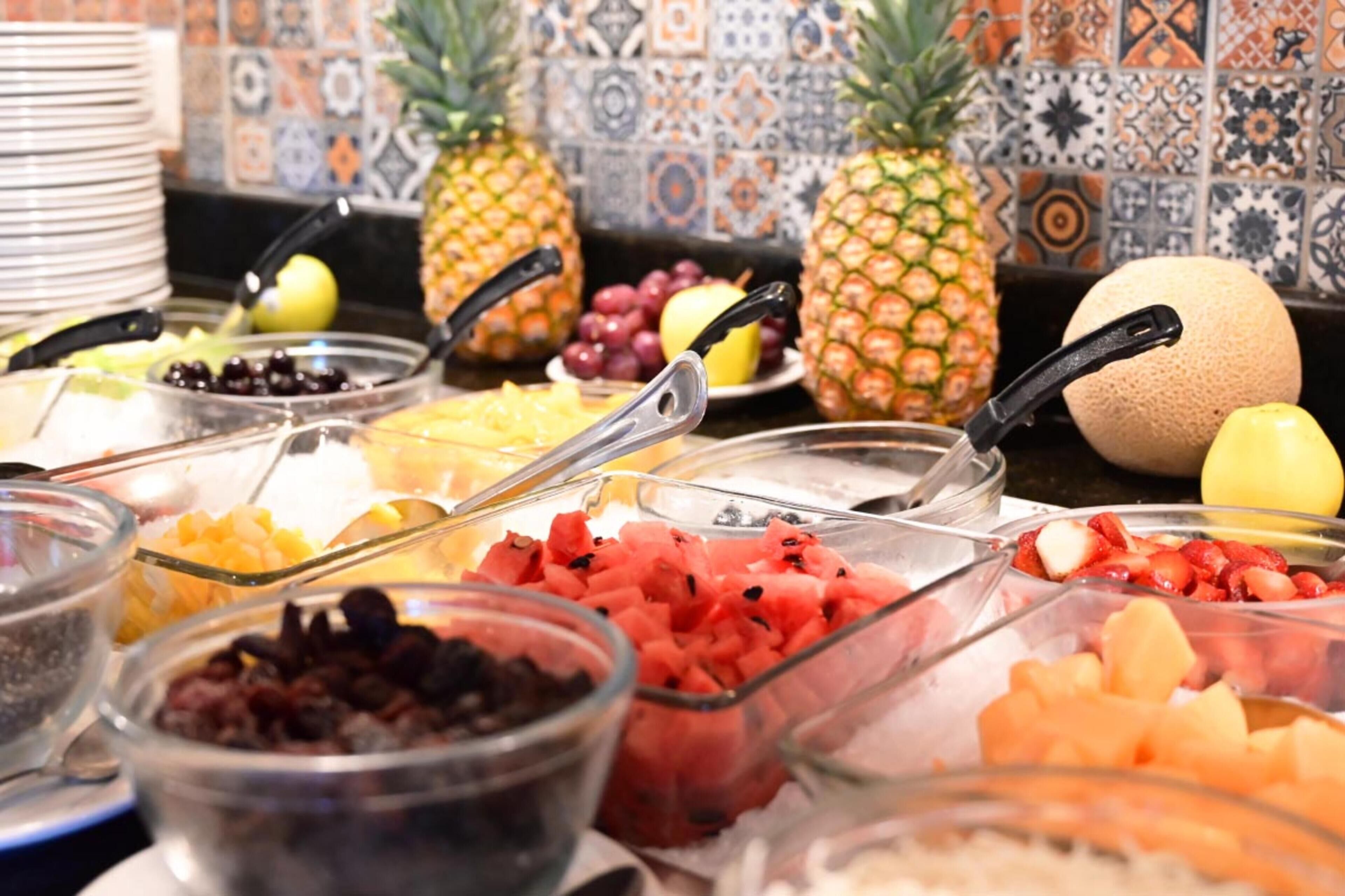 Un buffet garni de divers fruits et un mur recouvert de carreaux.