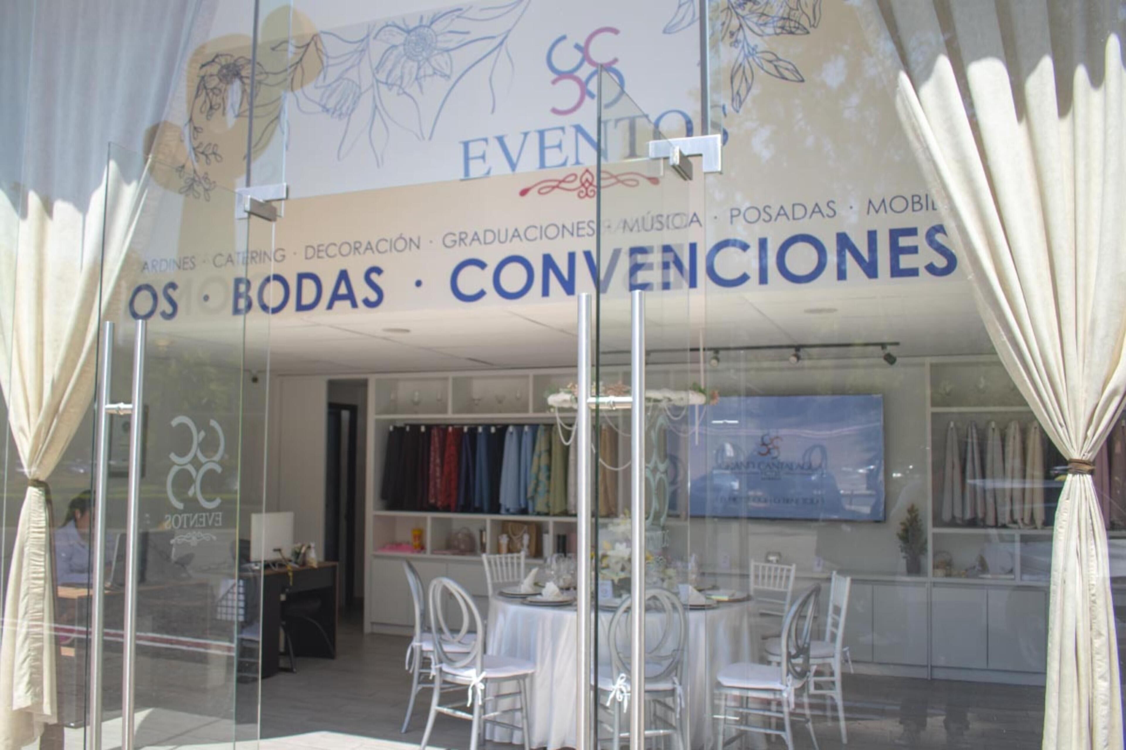 Une devanture de magasin avec une enseigne indiquant « ÉVÉNEMENTS, MARIAGES, RÉCEPTIONS » et une exposition de chaises et de tables à l’extérieur.