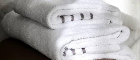 A stack of white towels on a metallic bench with a decorative edge.