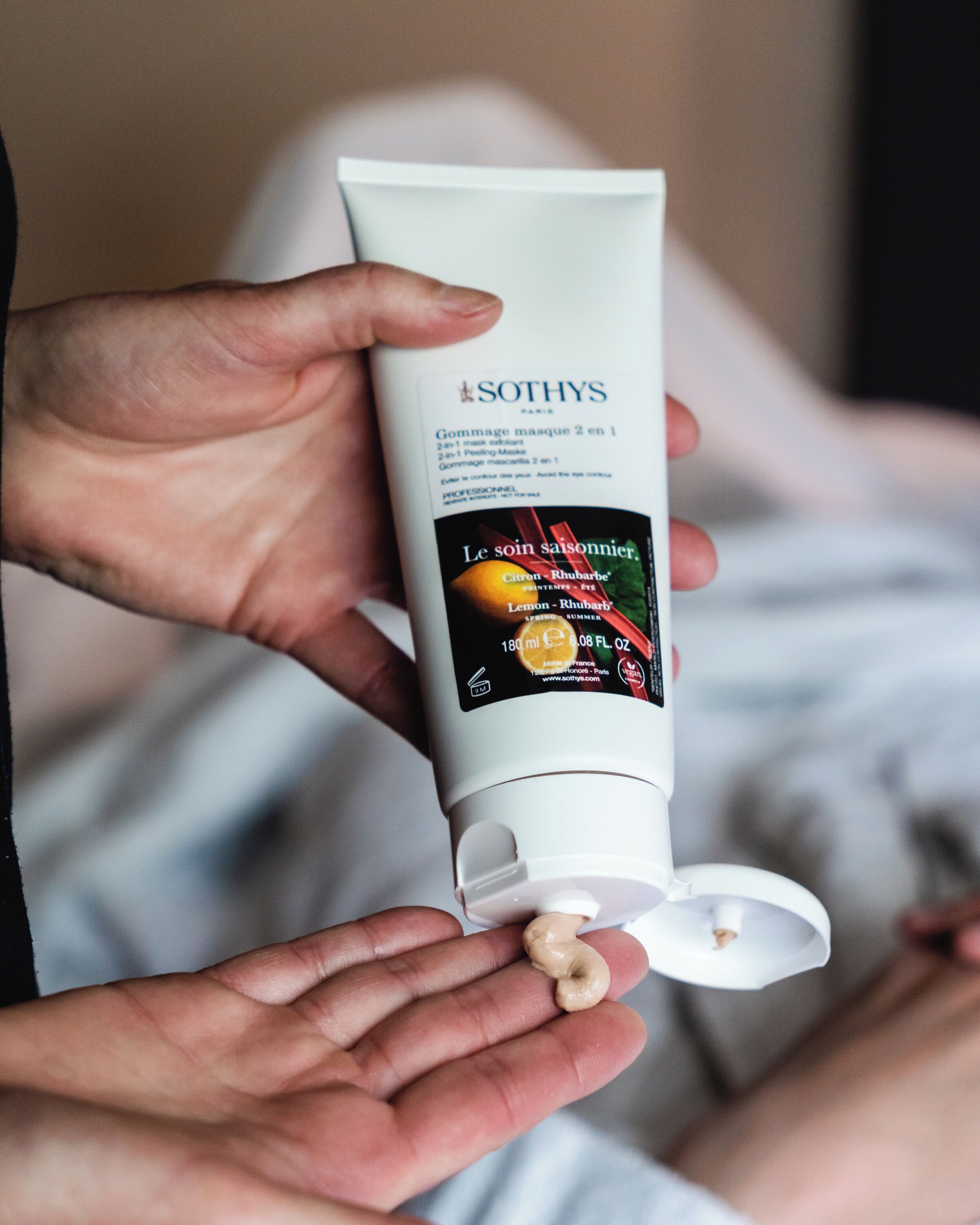 A person holding a tube of Sothys skincare product.