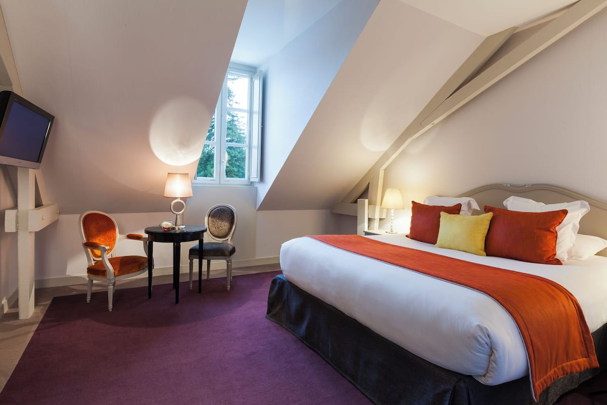 Une chambre à coucher avec un grand lit, un bureau, une chaise et un téléviseur.