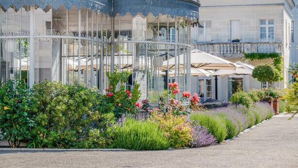 A garden with a gazebo, a building with a balcony, and a pathway. - Château Belmont Tours by The Crest Collection (Tours)