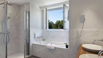 A modern bathroom with a glass-enclosed shower, a freestanding bathtub, and a vanity with a sink.