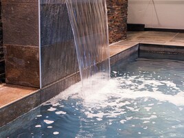 Um recurso hídrico com uma cascata desaguando em uma piscina.