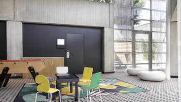 A modern interior with a black door, a small table with chairs, and a large window.