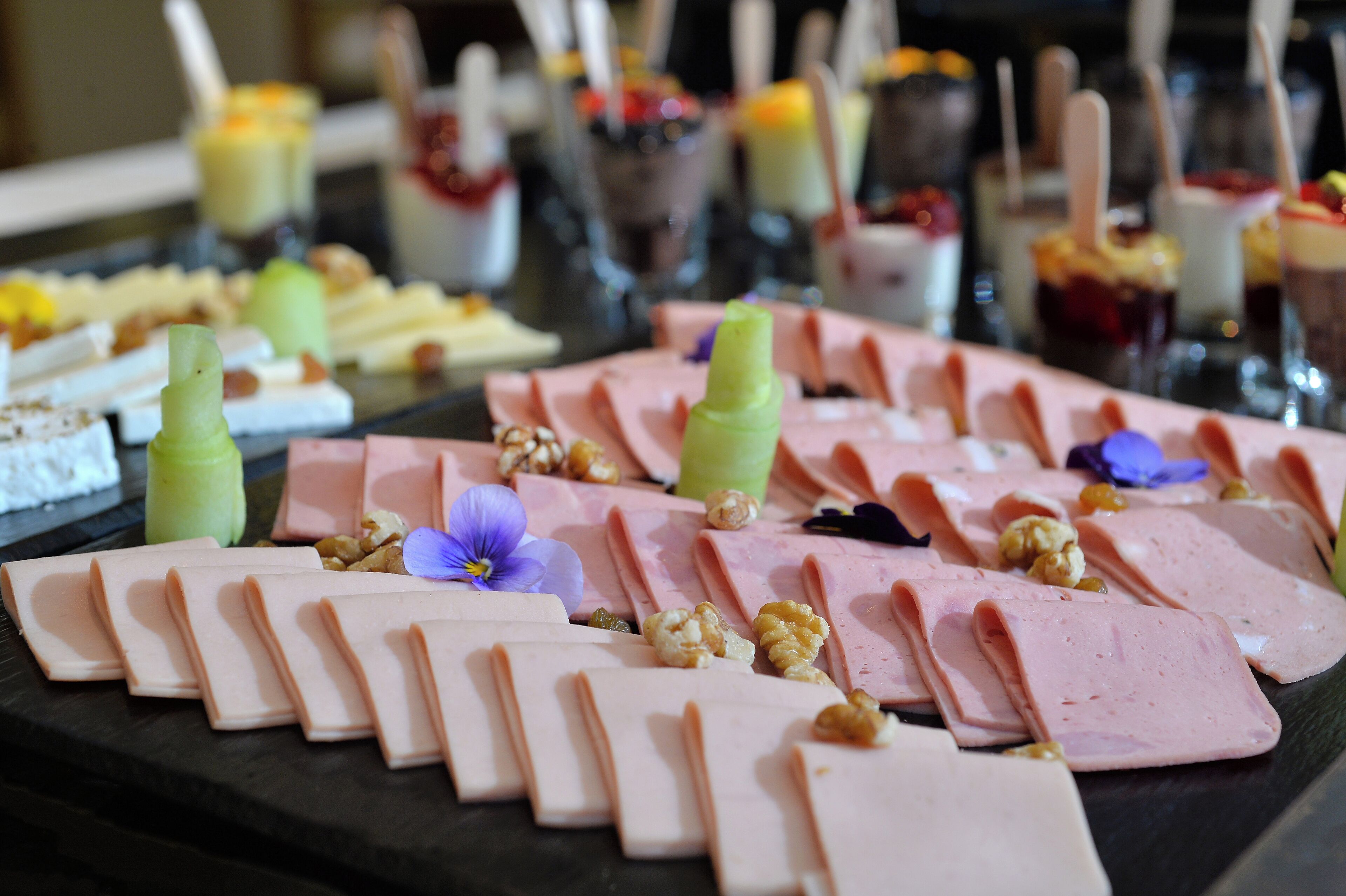 A variety of food items including sliced meats and nuts arranged on a platter.