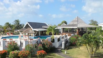 Relax by the resort's central pool surrounded by lounge chairs and umbrellas, or unwind in the shaded patio area.