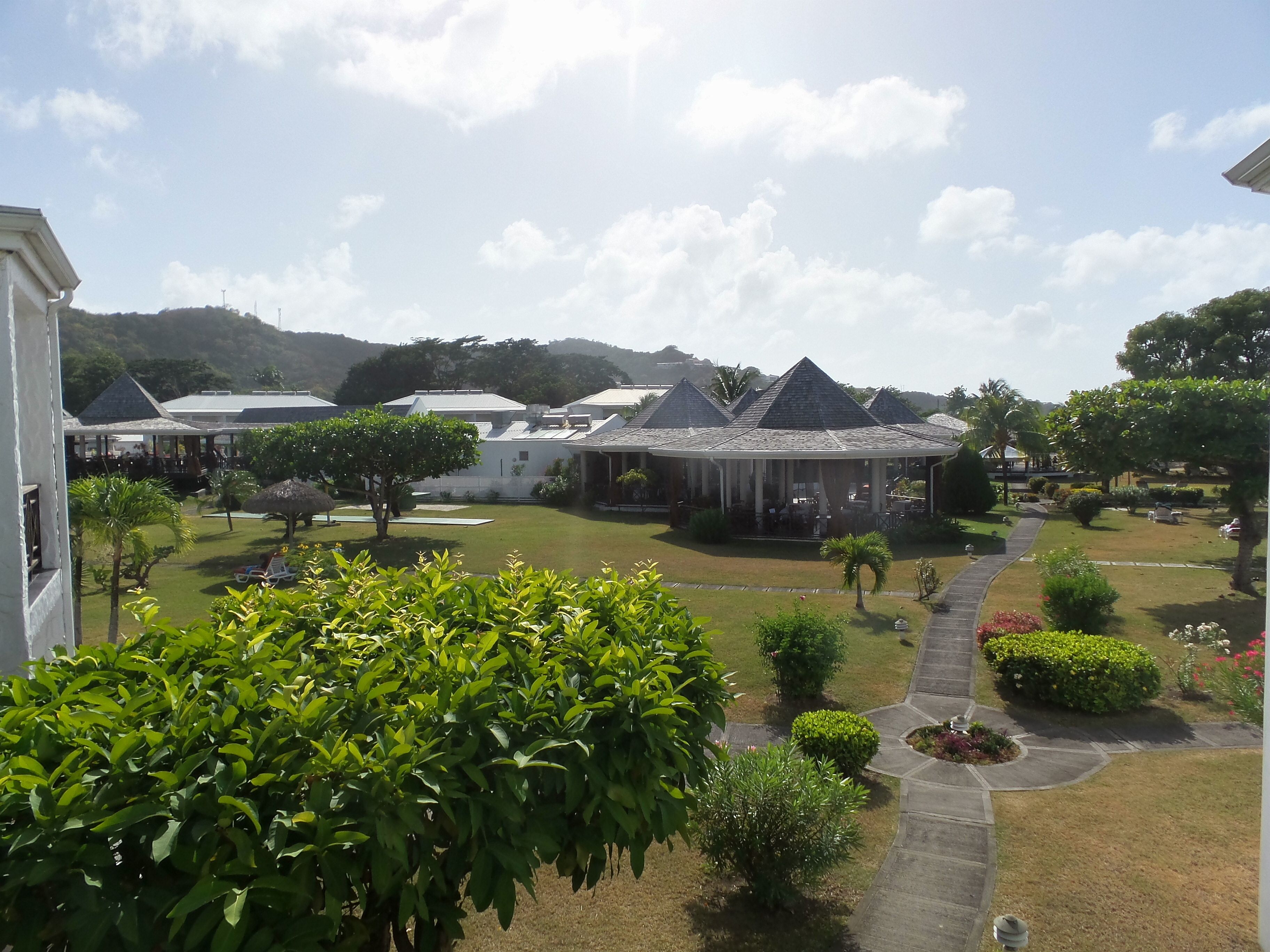 A resort with multiple buildings, a well-maintained lawn, and a clear sky.