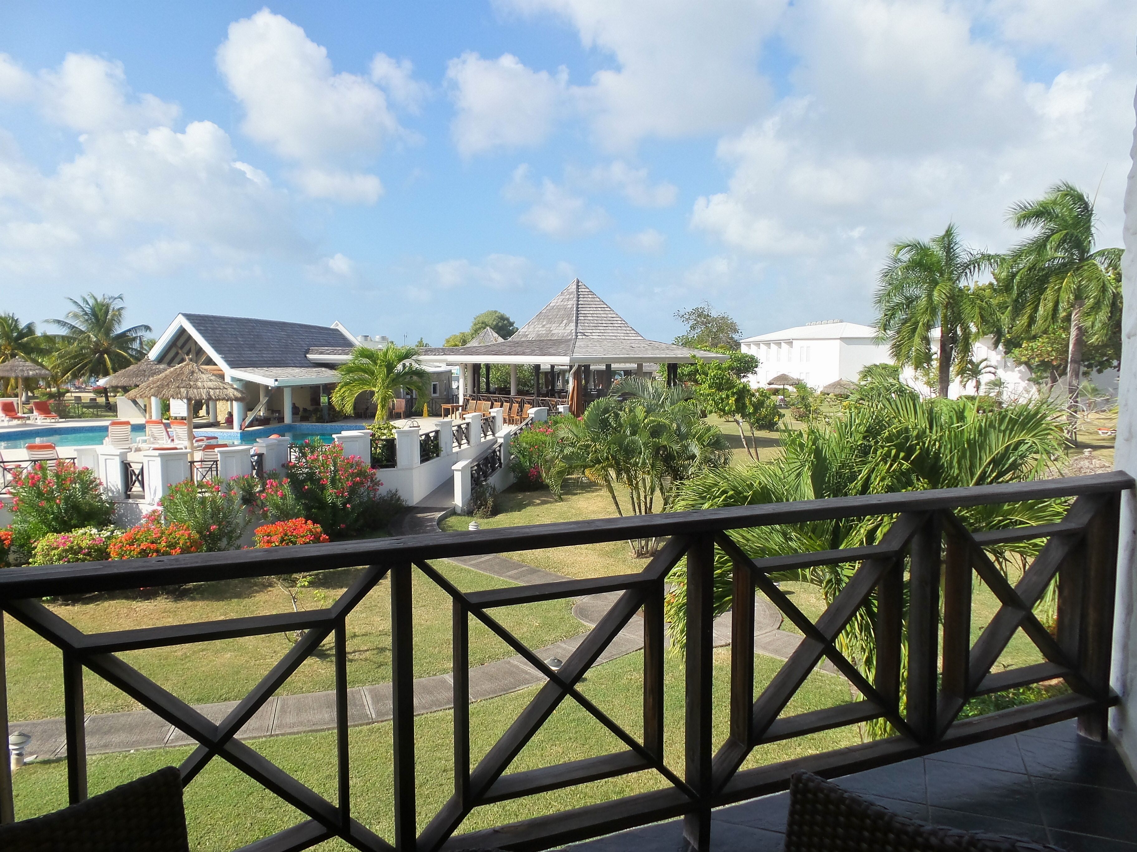 A resort with a swimming pool, lounge chairs, and a view of the surrounding landscape.