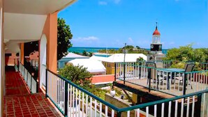 A balcony with a view of the ocean and a lighthouse.