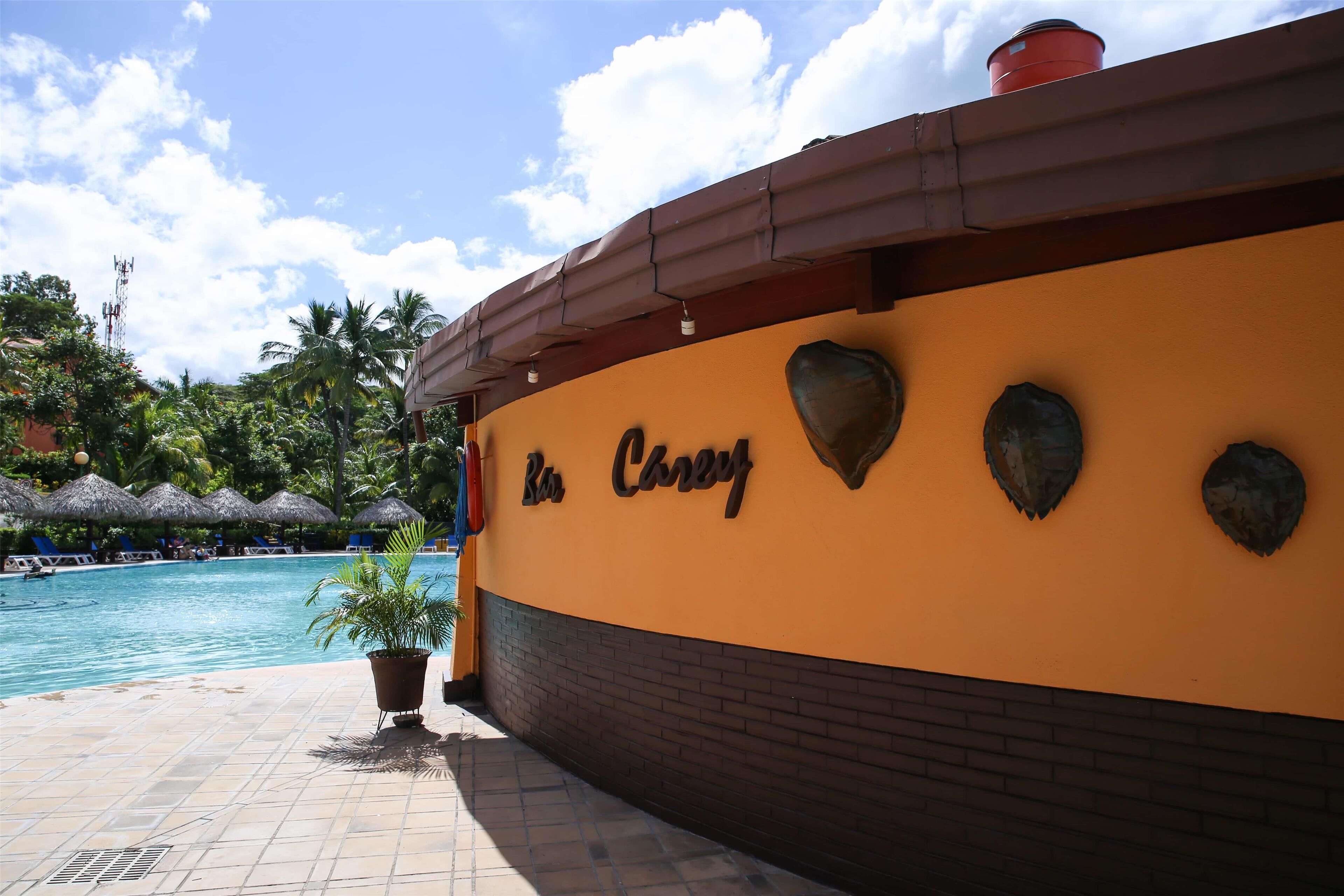 A pool area with a sign reading "Rosa Carey" and a brick wall.