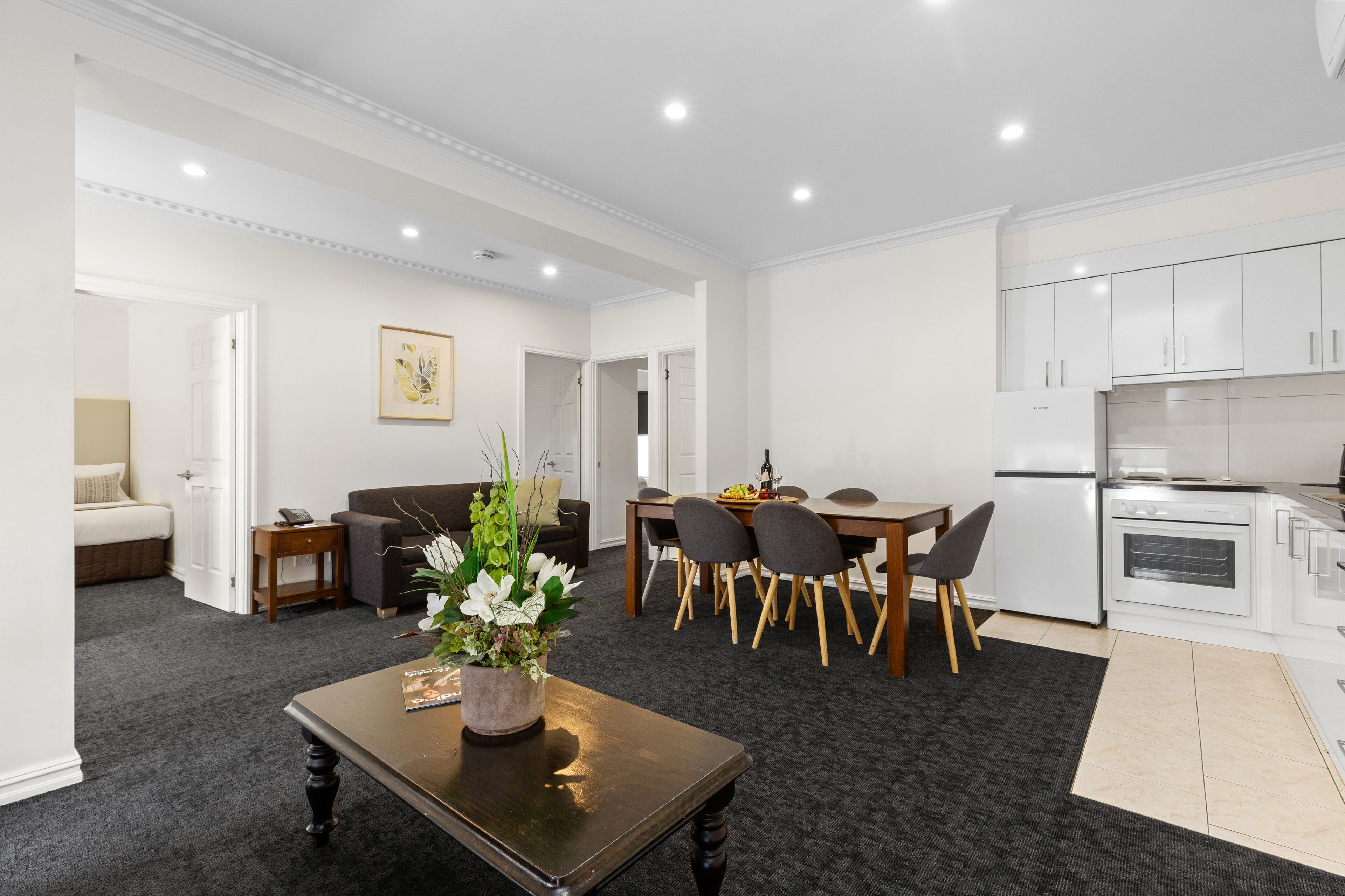 A modern living room with a dining area and kitchen.