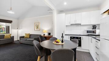 A modern living space with a dining area, kitchen, and seating area.