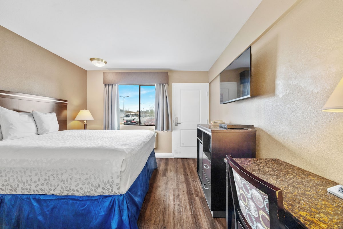 Une chambre d’hôtel avec un lit, un bureau et une télévision.