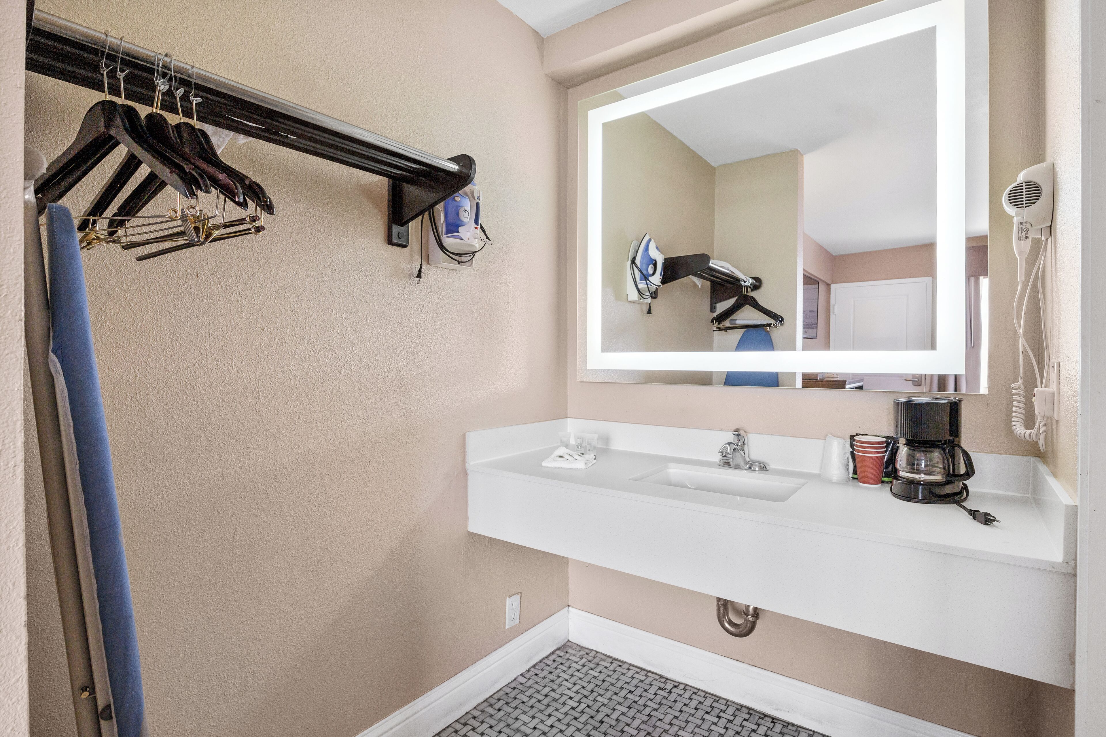 A bathroom with a sink, mirror, and towel rack.