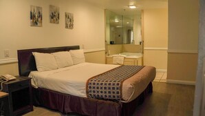 A hotel room with a bed, a bedside telephone, a nightstand, and a bathroom visible through an open door. - Country Inn (Ontario)