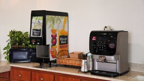 A coffee machine, a microwave, and a Minute Maid juice dispenser on a kitchen counter. - Country Inn (Ontario)