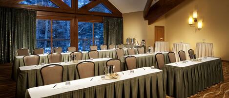 A conference room with long tables, chairs, and a chandelier.