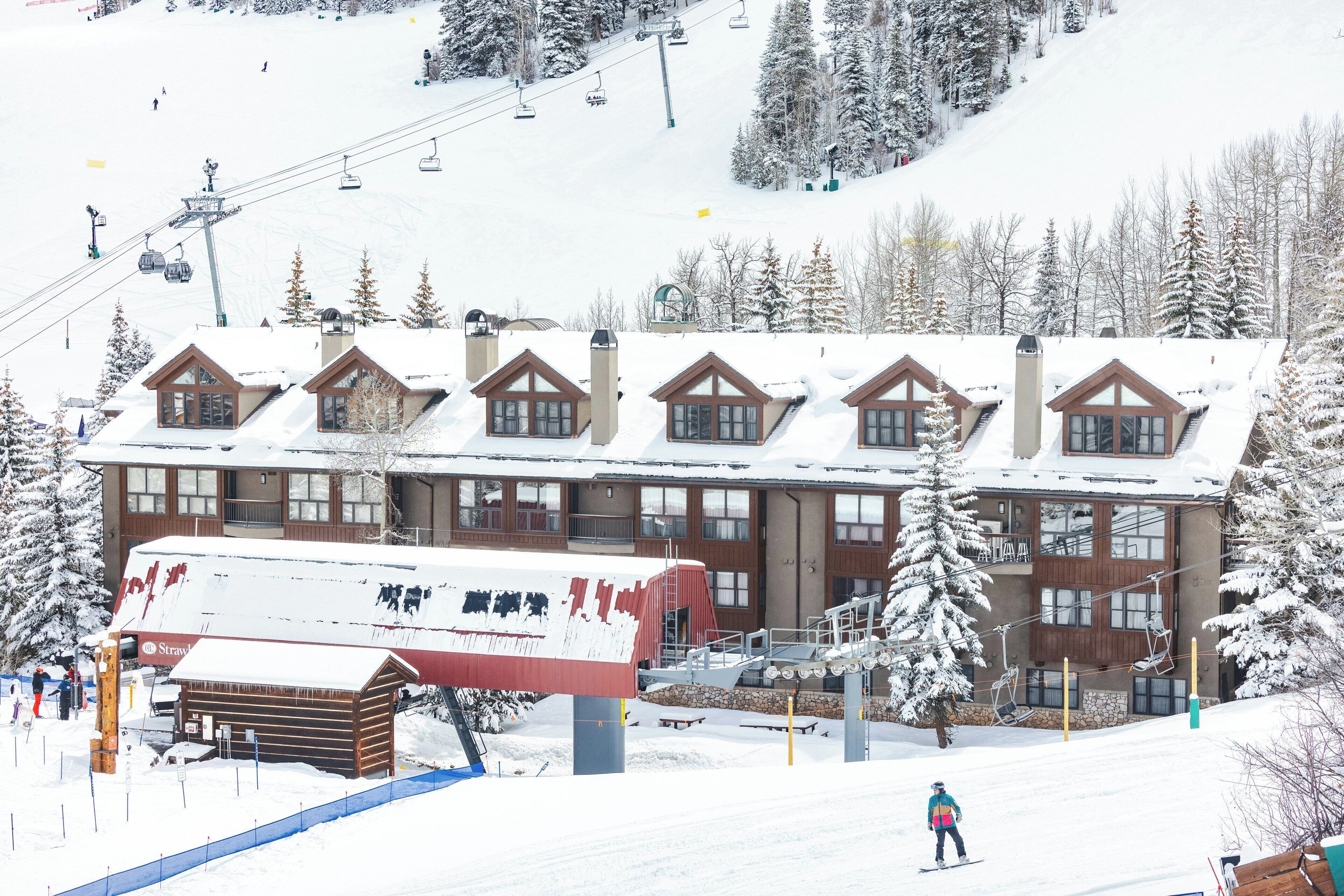 A ski resort building with multiple windows and a ski lift in the background.