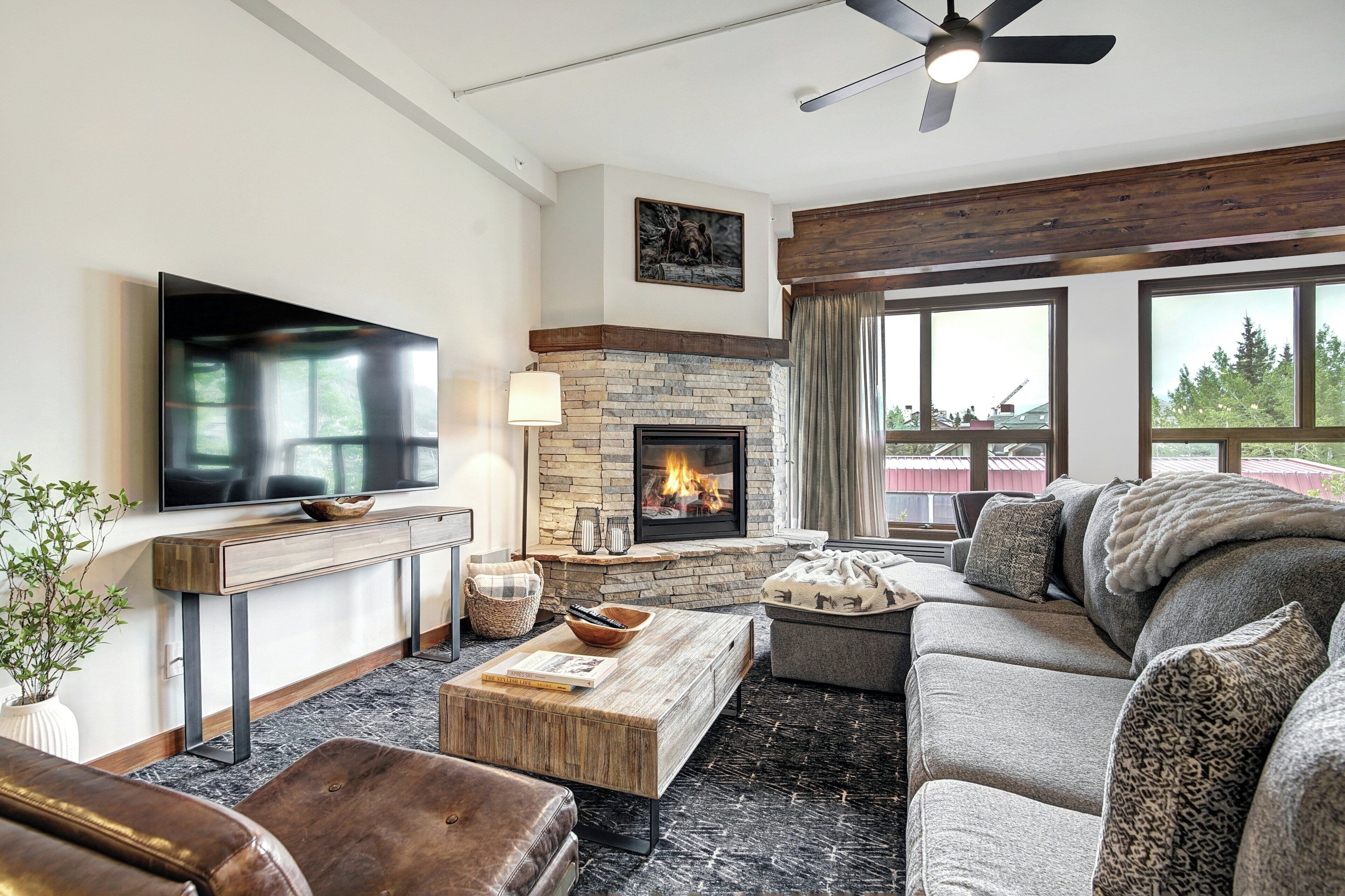 A living room with a flat-screen TV, fireplace, sofa, and coffee table.