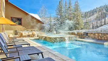 Una piscina al aire libre, sillones reclinables de piscina