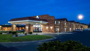 A hotel with a brick facade, a gas station sign, and a parking lot. - Days Inn by Wyndham Anderson IN (Anderson)