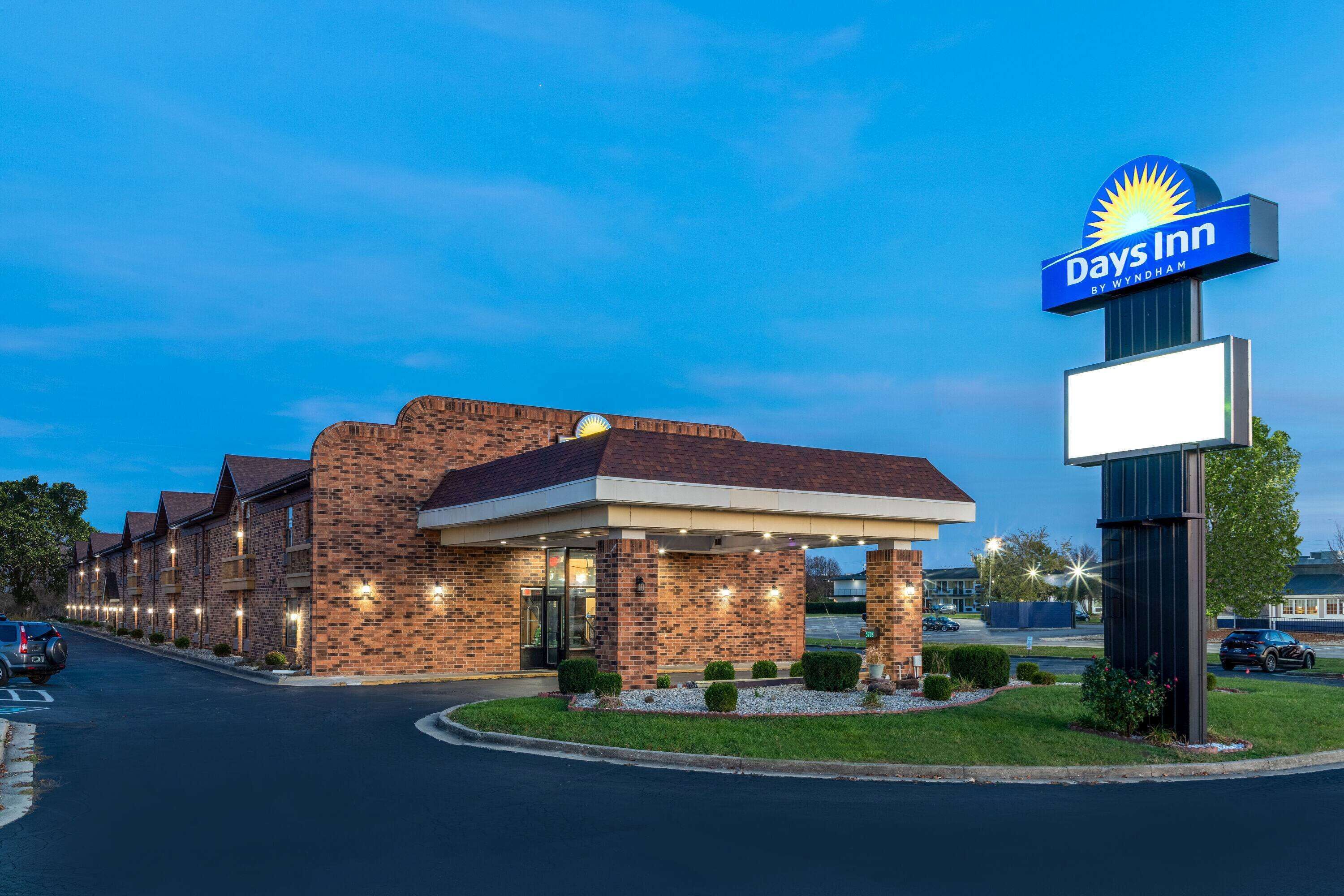 A Days Inn hotel with a brick facade, a covered entrance, and a parking lot.