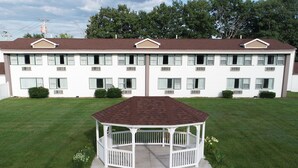 A white two-story building with a central garden gazebo.