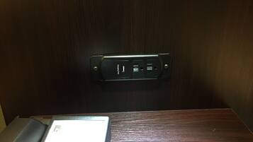 A wooden wall with a black charging station displaying a charging icon.