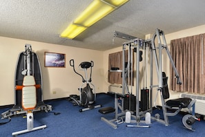 A gym with exercise equipment, a blue carpet, and a picture on the wall. - Red Roof Inn Gallup (Gallup)