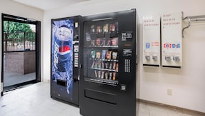 A vending machine with a Pepsi advertisement and a selection of snacks and beverages. - Red Roof Inn Gallup (Gallup)