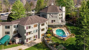 Un edificio de varios pisos con piscina y un patio cubierto.