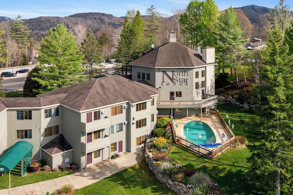 A multi-story building with a pool and a covered patio area.