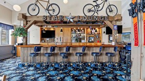 Zona de bar con un letrero de estrella, bicicletas y una alfombra estampada.