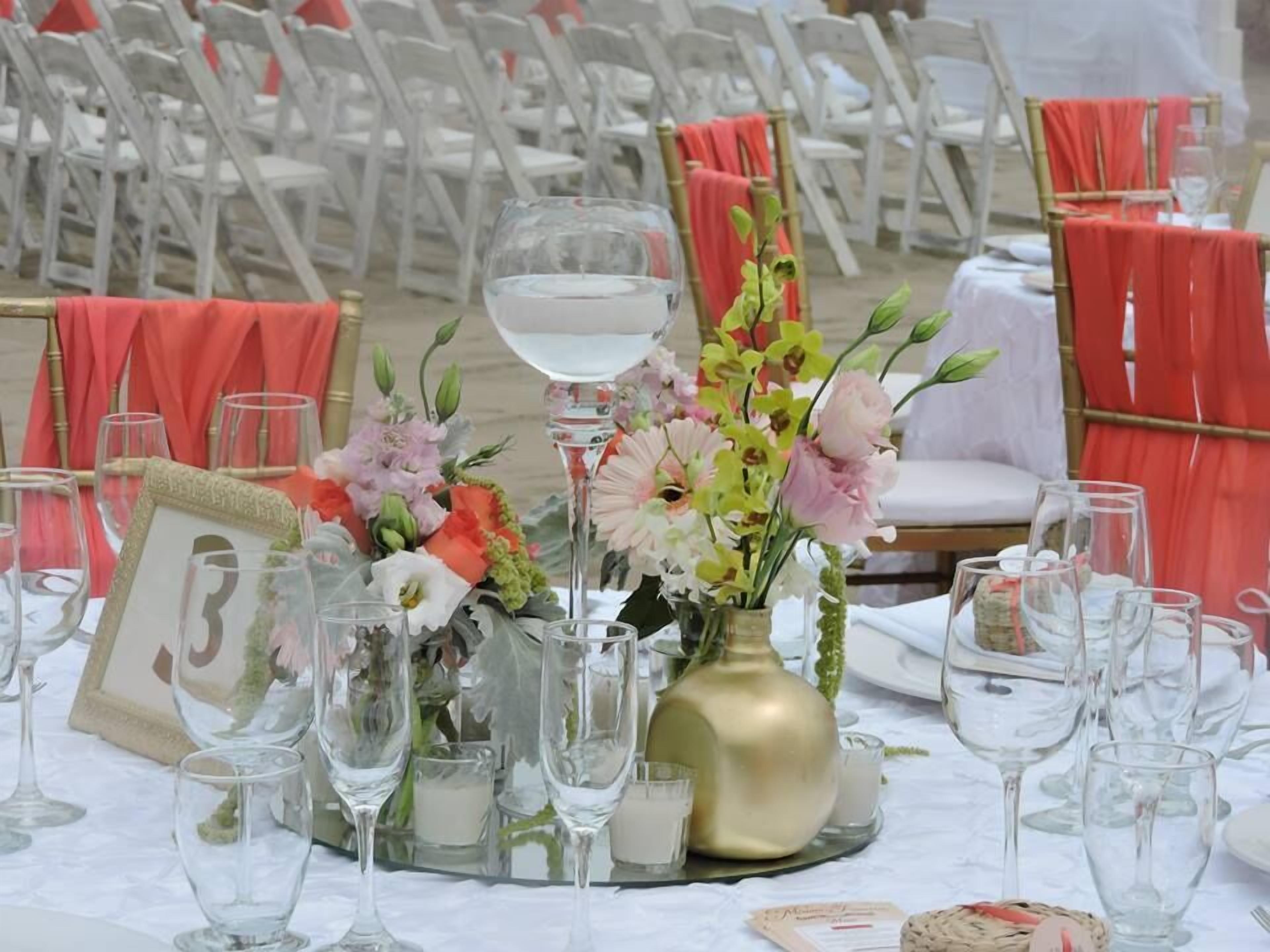 A table set for a formal event with floral centerpieces, numbered place cards, and wine glasses.