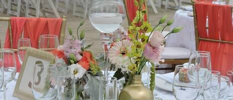 A table set for a formal event with floral centerpieces, numbered place cards, and wine glasses.