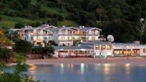 A hotel with multiple buildings, a pool, and a waterfront view.