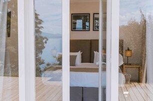 Un dormitorio con cama, mesita de noche y lámpara. En la pared hay cuadros enmarcados.