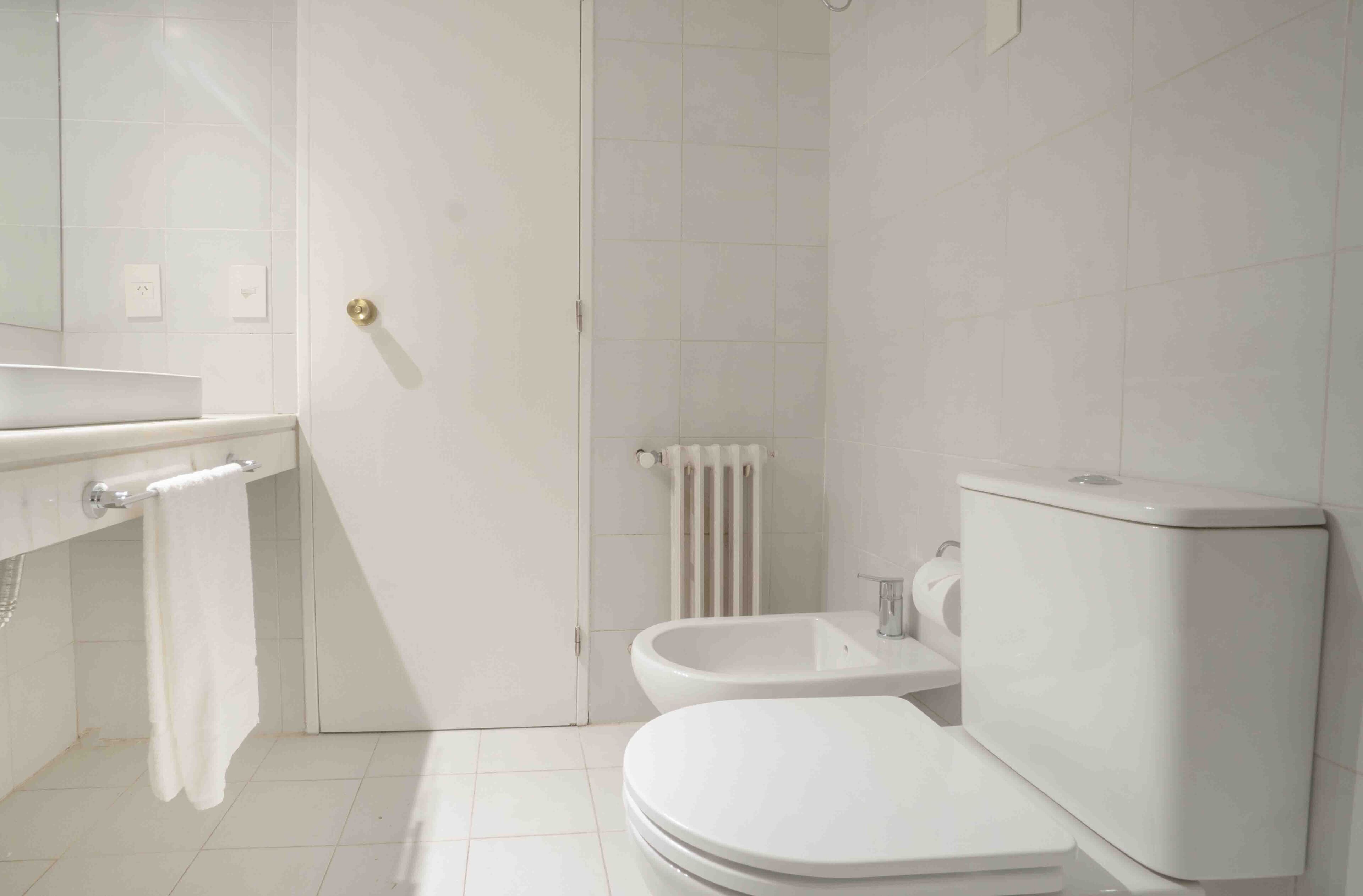 A modern bathroom with a toilet, bidet, and sink.