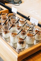 Een schaal met yoghurt parfait, granola en een bordje met de tekst 'Joghurt mit Granola'.