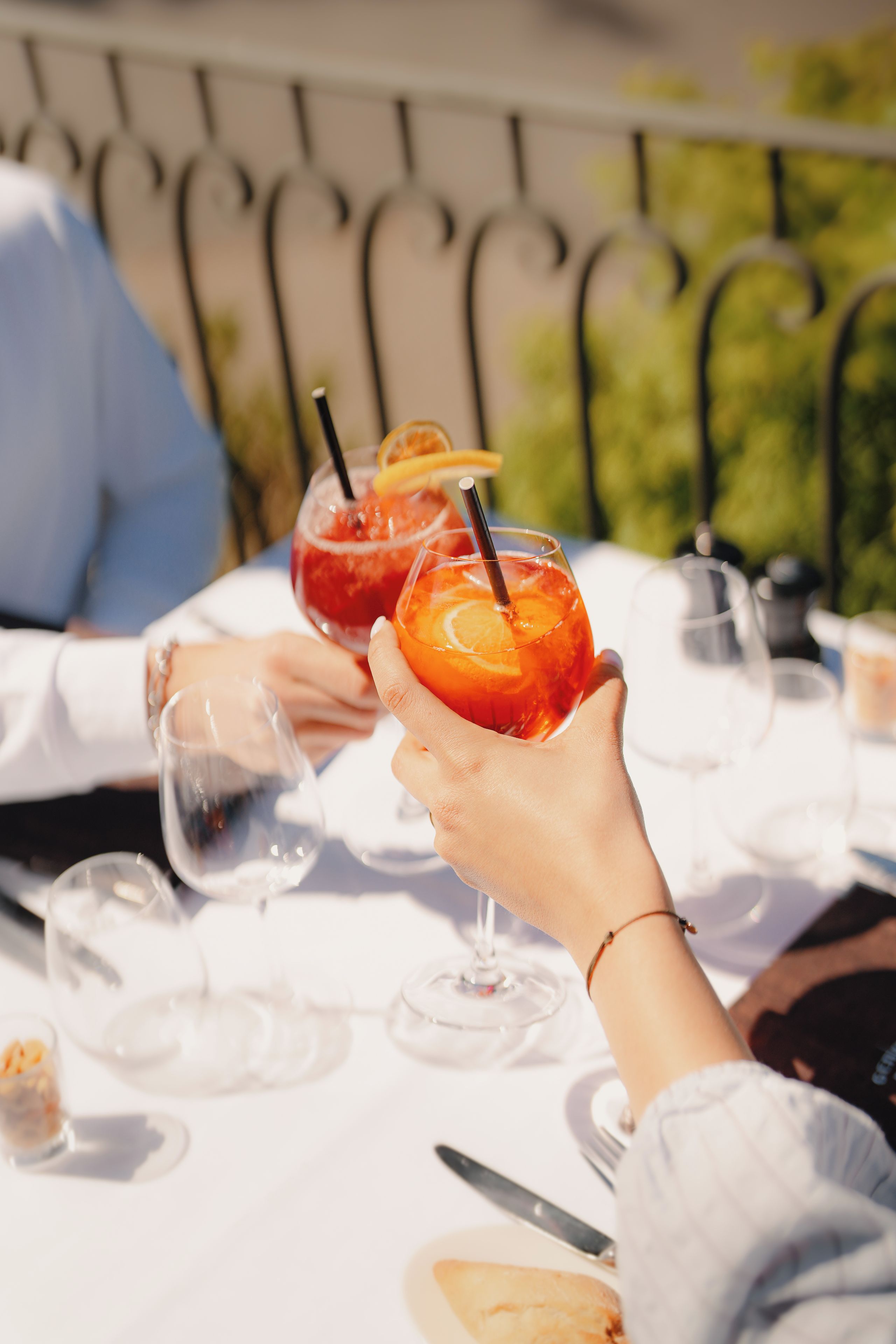Une table avec deux boissons, un verre d’eau et une assiette de nourriture.