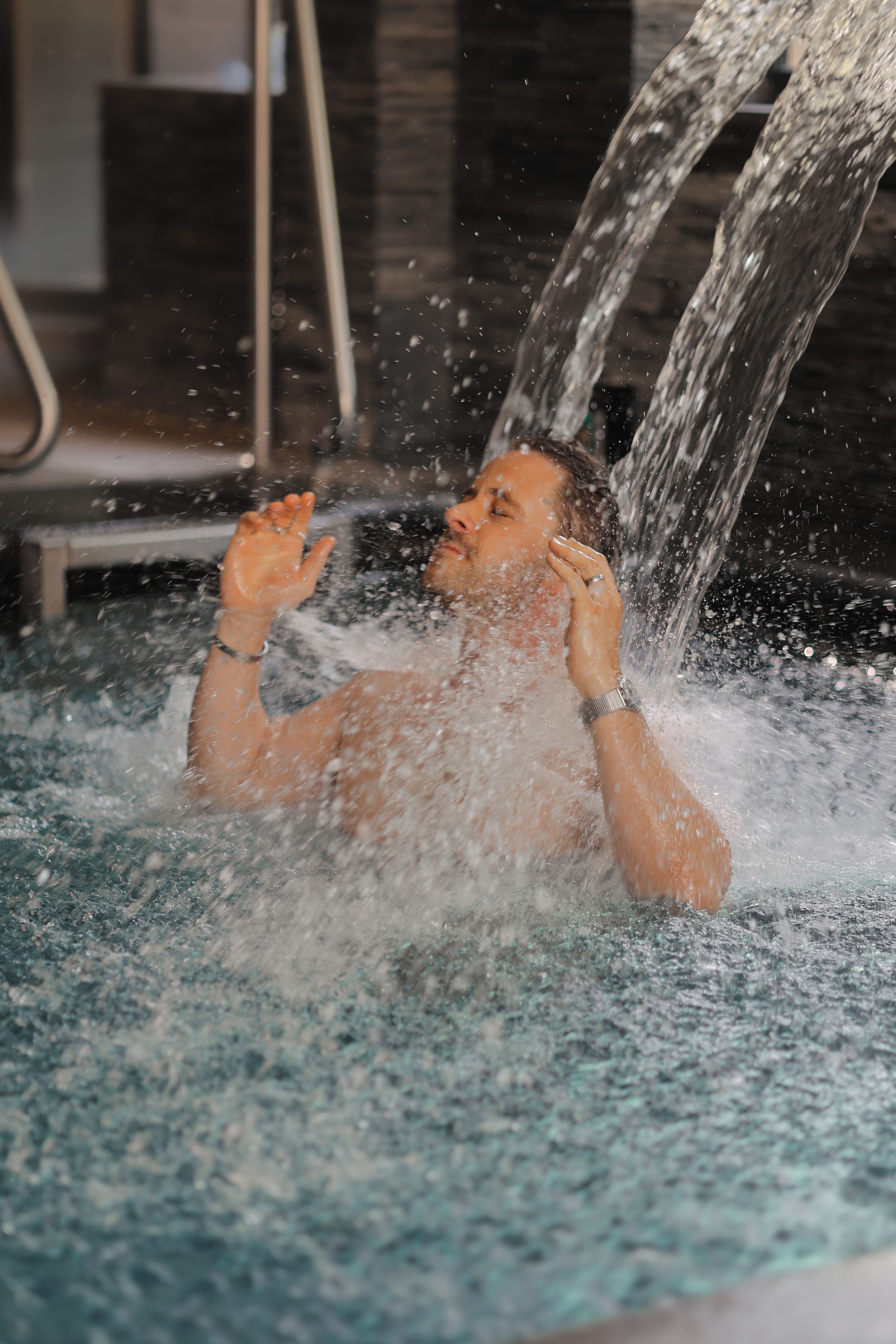 Una persona en una piscina con agua salpicando a su alrededor.